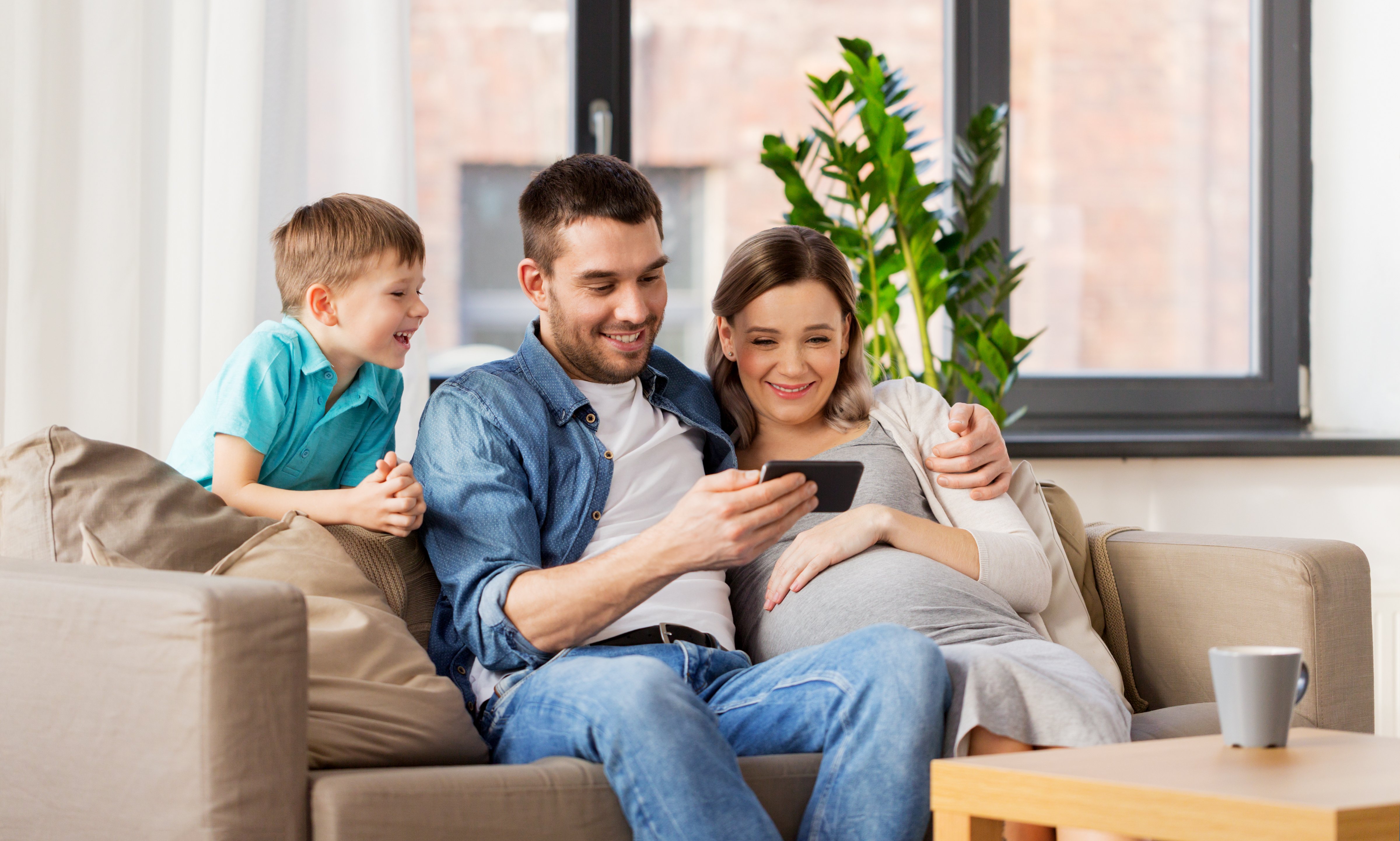FamilyLookingAtPhoneOnCouch