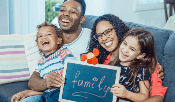 happy family holding a chalkboard sign - family engagement platform