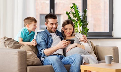 FamilyLookingAtPhoneOnCouch copy